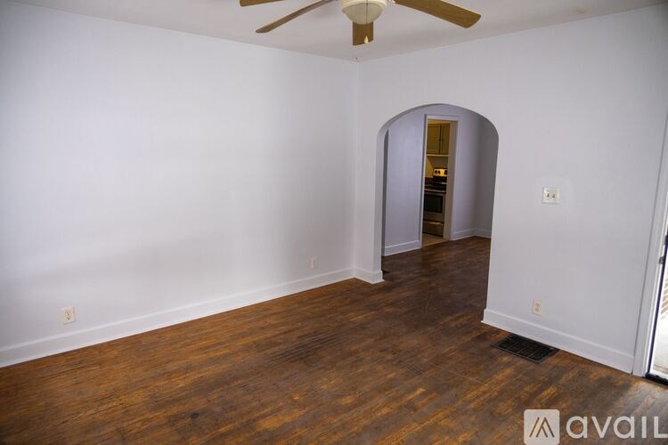 A room with a wooden floor and a ceiling fan.