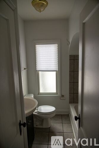 A bathroom with a toilet, sink and window.