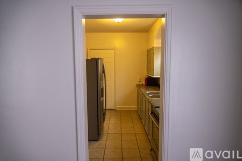 A kitchen with a refrigerator and a sink.