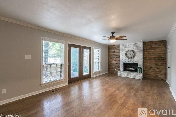 A living room with a fireplace and a ceiling fan.