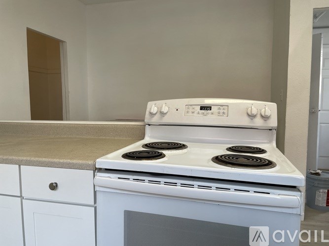 A white stove top oven with four burners and a white oven door.