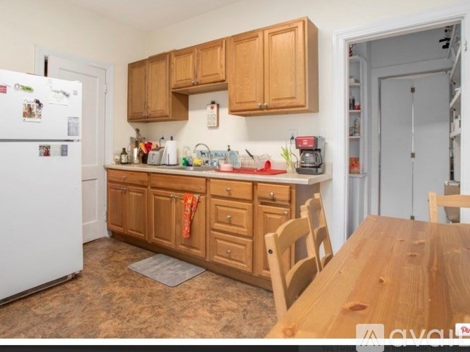 A kitchen with wooden cabinets and a white fridge.