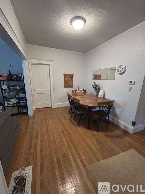 A dining room with a wooden table and chairs.