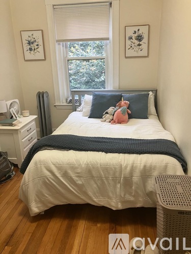 A bedroom with a bed, nightstand, and window.