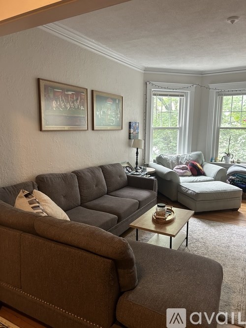 A living room with a grey sectional sofa and a brown sofa.