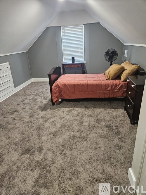 A bedroom with a bed and a fan.