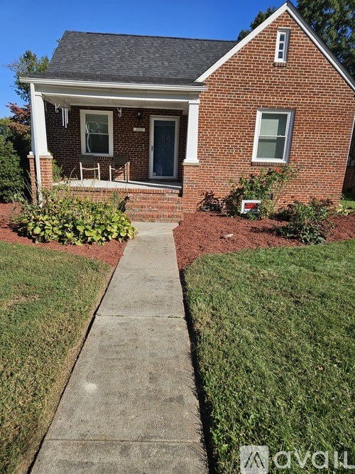 A red brick house with a white door and window.