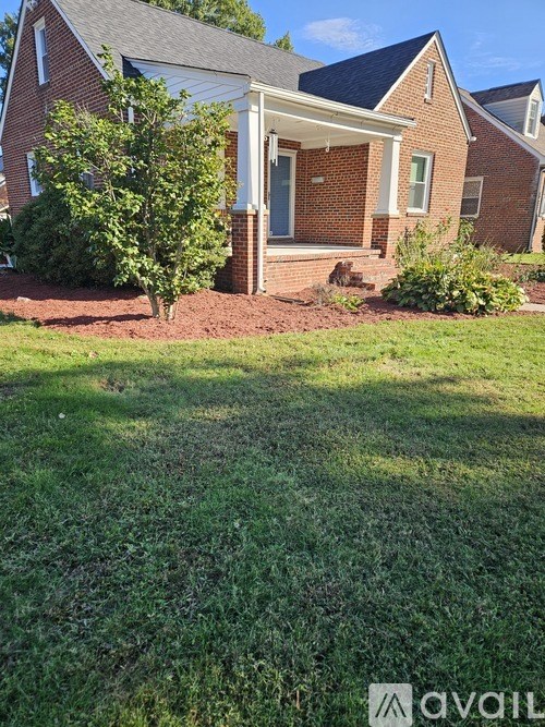 A house with a red brick exterior and a white porch.