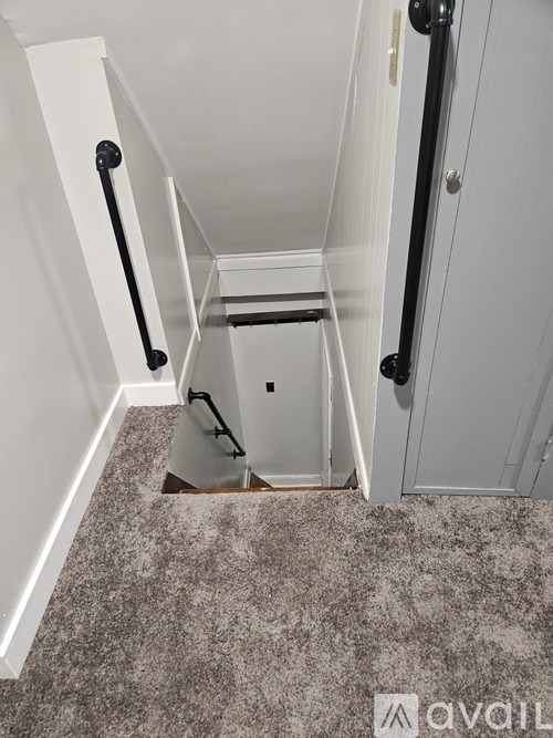 A small white closet with a carpeted floor and a white door.