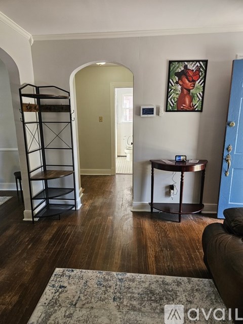 A living room with a brown couch and a blue rug.