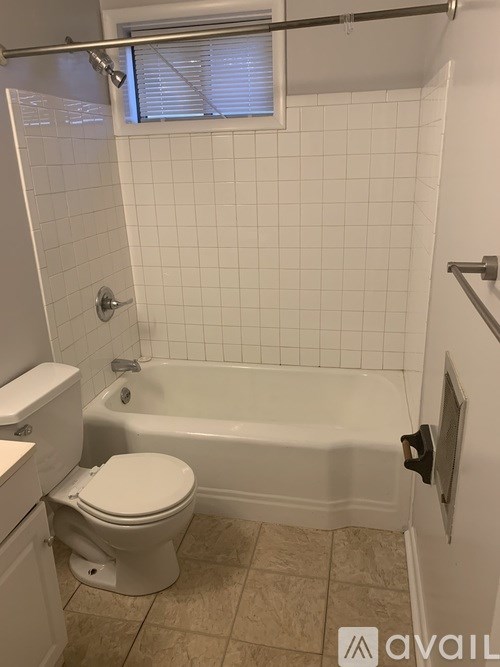 A white toilet sits next to a bathtub in a bathroom.