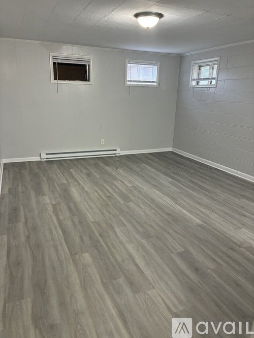 A hallway with white walls and a tiled floor.