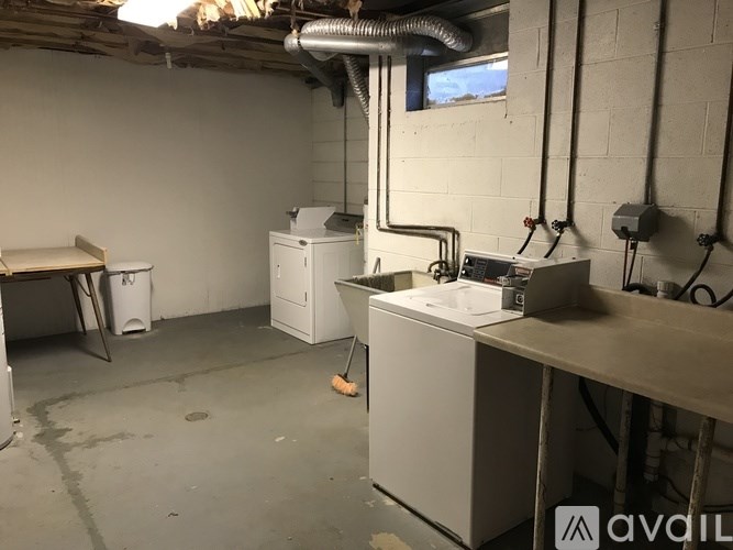 A room with a white wall and a window, with a white machine on the floor.