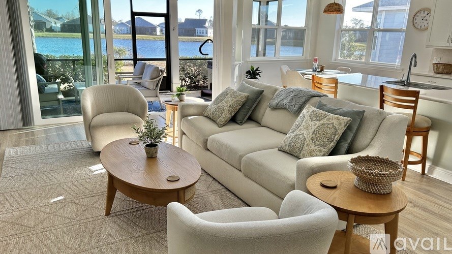 A living room with a couch, chairs, and a table with a plant on it.