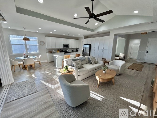 A modern living room with a grey sofa set, a wooden coffee table, and a ceiling fan.
