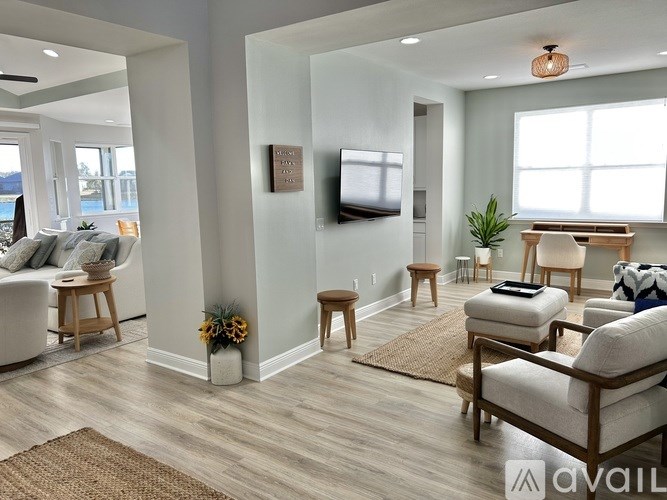 A living room with a television, couch, and chairs.