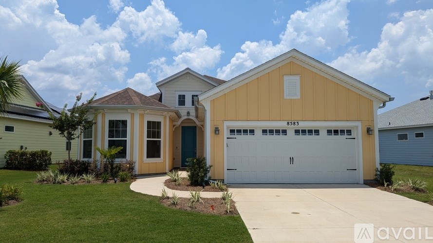 A house with a garage and a driveway in front of it.
