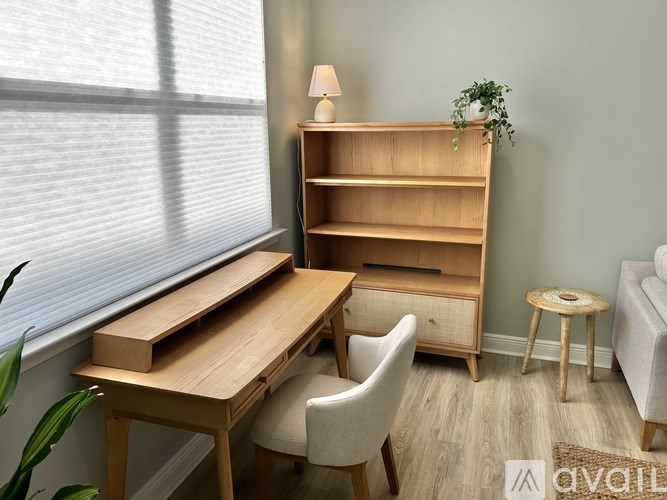 A room with a desk, chair, and bookshelf.