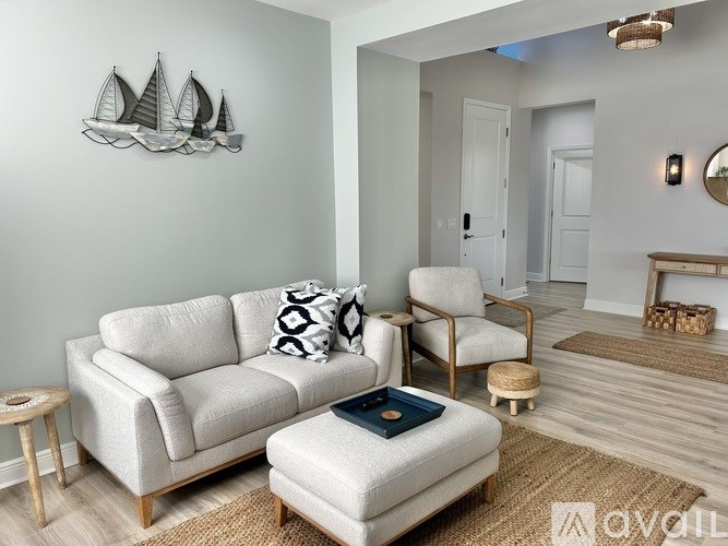 A living room with a white couch, a chair, and a small table.