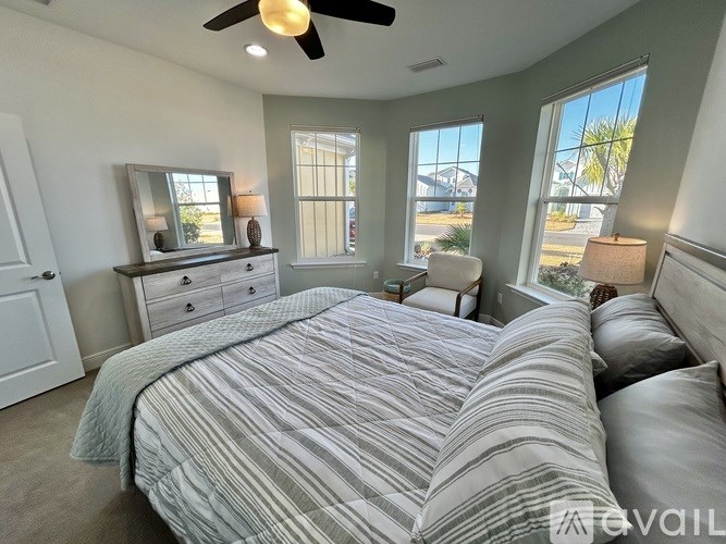 A bedroom with a large bed and a ceiling fan.