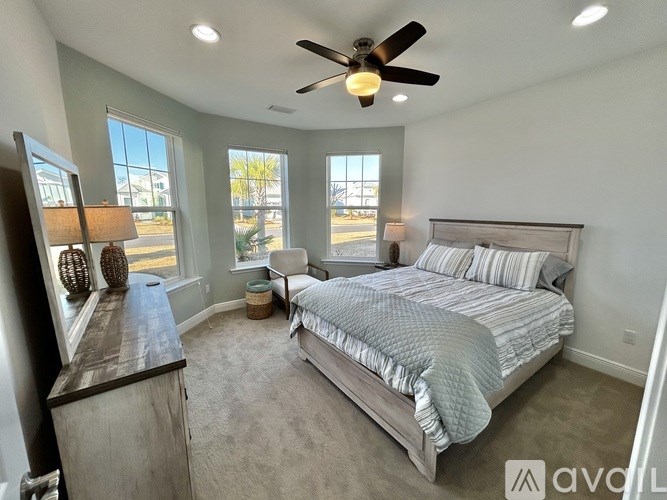 A bedroom with a large bed and a ceiling fan.