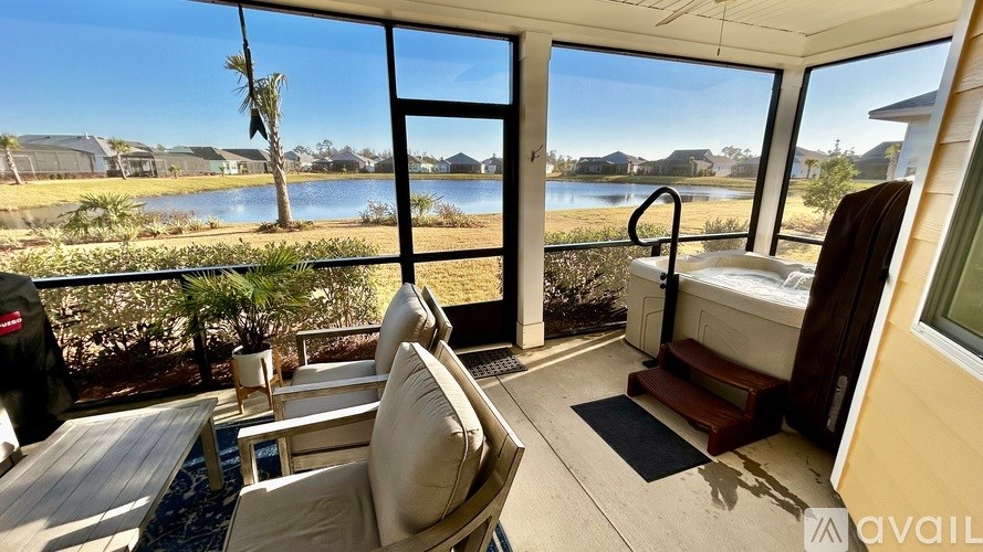 A balcony with a chair and a table overlooking a body of water.