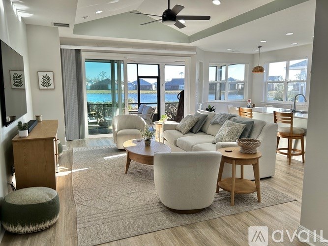 A spacious living room with a view of the outdoors through large windows.