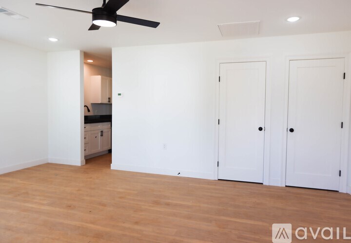 A room with a ceiling fan and wooden flooring.