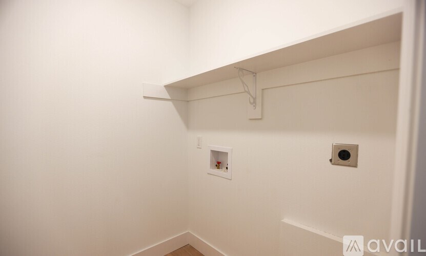 A white wall with a coat rack and two small holes.