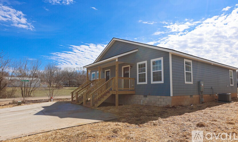 A house with a grey exterior and a wooden deck.