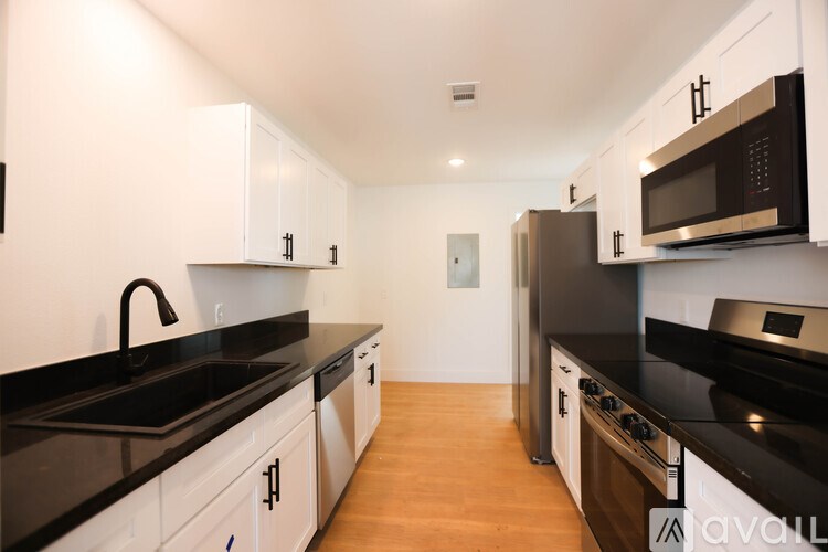 A kitchen with black countertops and white cabinets.