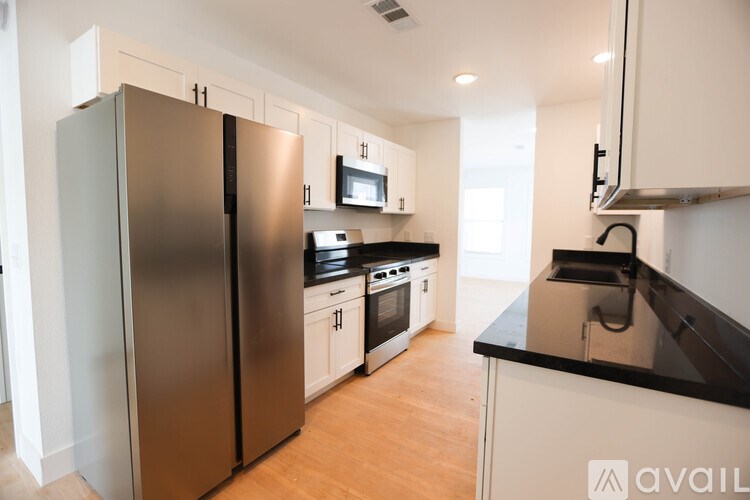 A kitchen with a black countertop and stainless steel appliances.