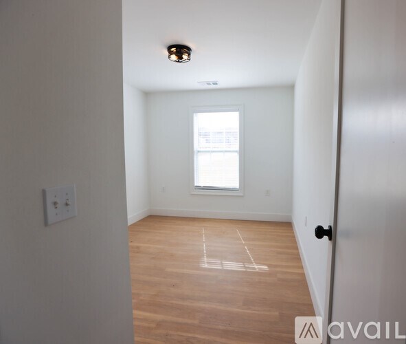 A room with wooden flooring and a window.