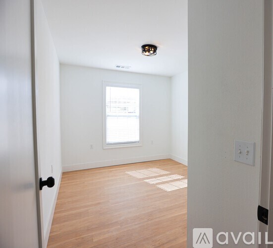A room with a window and wooden flooring.