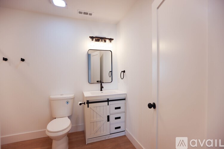 A white toilet sits next to a sink with a mirror above it.
