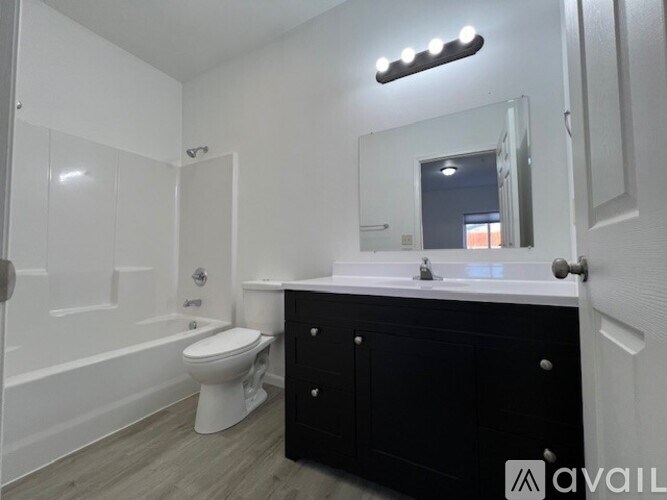 A bathroom with a white toilet, a sink, and a mirror.