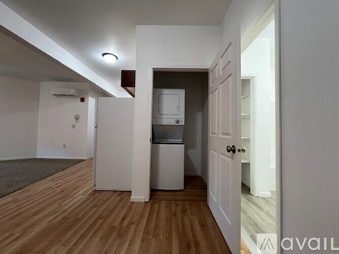 A kitchen area with a refrigerator and a washing machine.