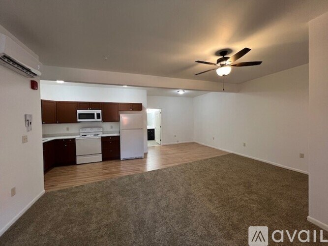 A spacious room with a kitchen area in the background.