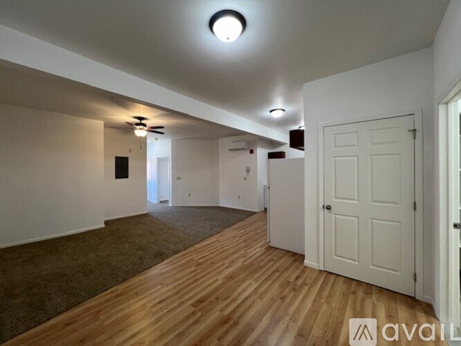 A room with wooden flooring and white walls.