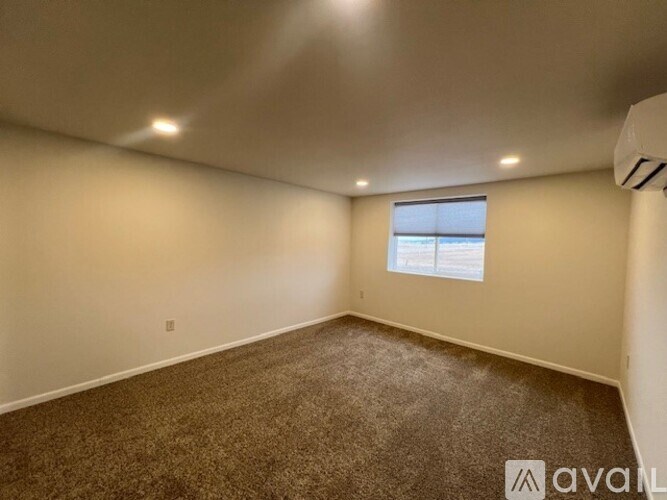 A room with a carpeted floor and a window.