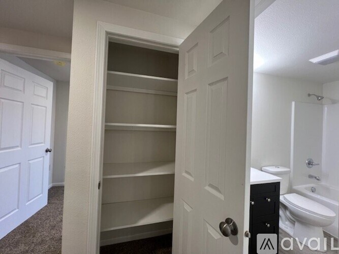 A white door is open to a bathroom with a toilet and sink.