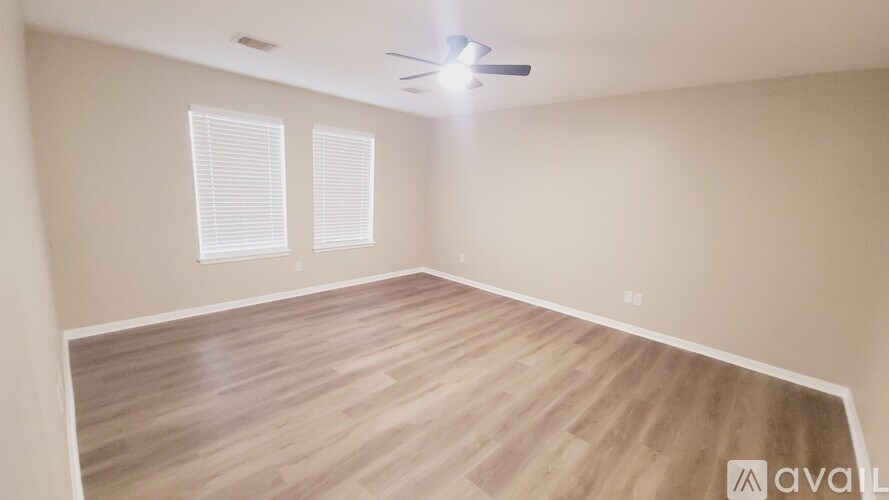 A room with wooden flooring and a ceiling fan.