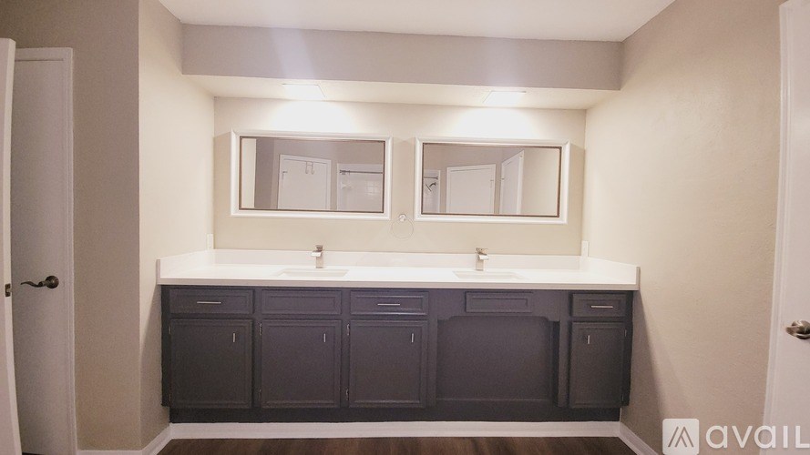 A bathroom with two sinks and a large mirror.