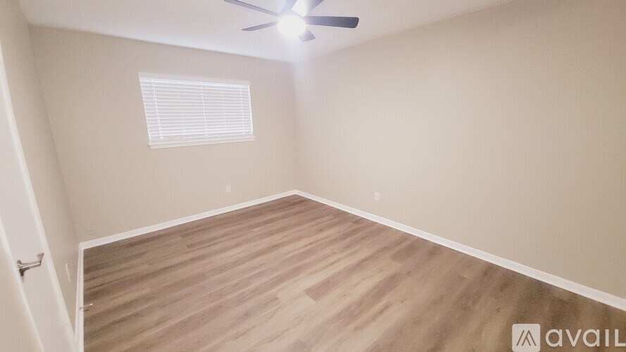 A room with wooden flooring and a ceiling fan.