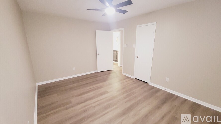 A room with a ceiling fan and two doors.