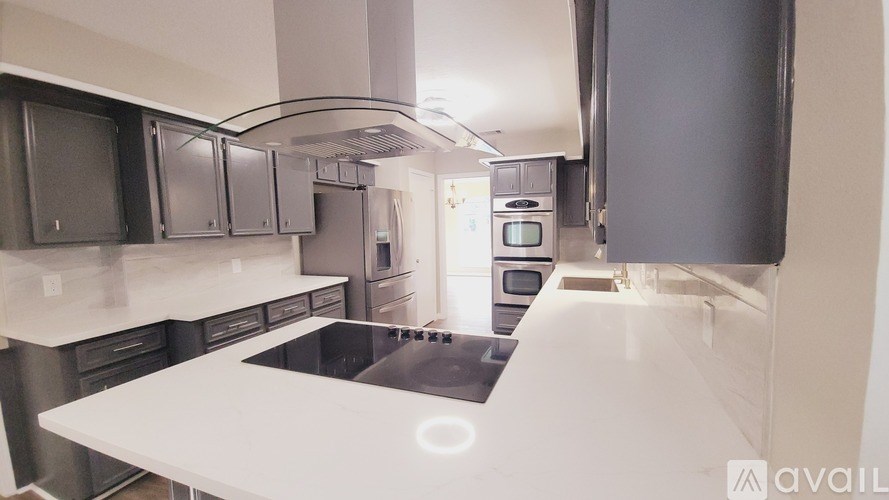 A kitchen with a white countertop and stainless steel appliances.