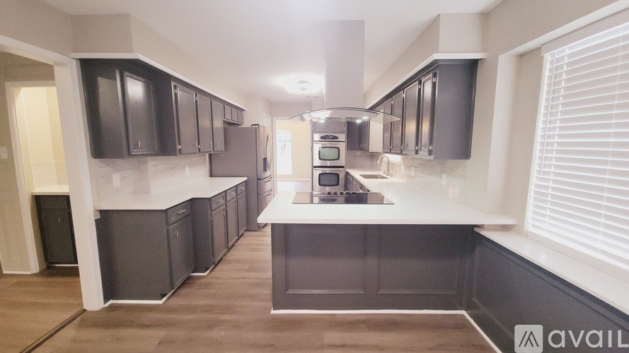 A kitchen with dark brown cabinets and a white countertop.