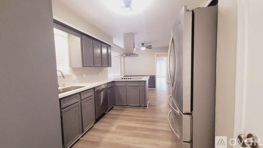 A kitchen with a refrigerator on the right side.