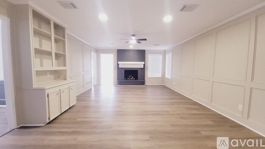 A spacious living room with a fireplace and built-in shelves.