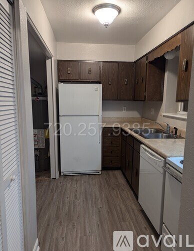 A kitchen with a white refrigerator and wooden cabinets.